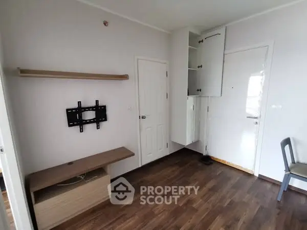 Minimalist room with wall-mounted TV bracket and wooden flooring, perfect for modern living.