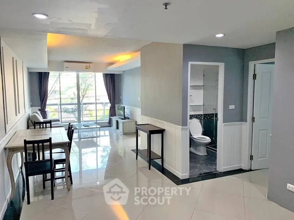 Spacious open-plan living area with modern decor and large windows for natural light.
