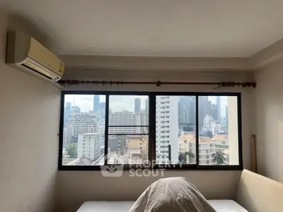 Spacious bedroom with city view and air conditioning in urban apartment