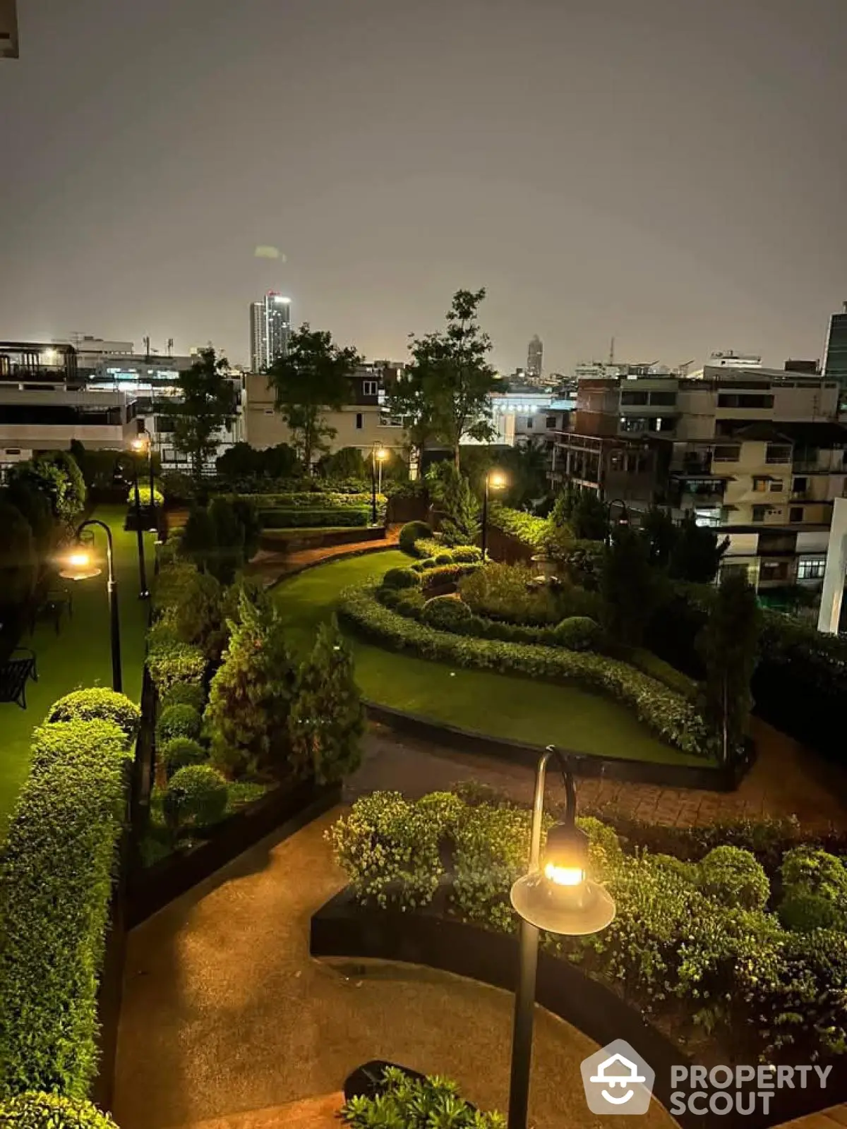 Stunning night view of a beautifully landscaped garden in a modern residential complex.