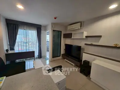 Modern living room with sleek furniture and large window offering natural light.