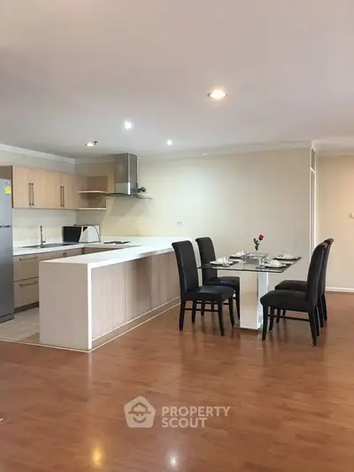 Modern open kitchen with dining area and sleek wooden flooring