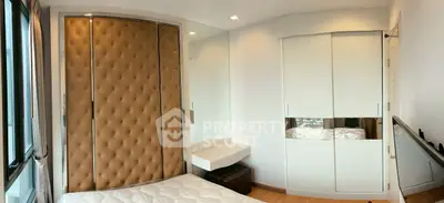 Modern bedroom with stylish padded wall and mirrored wardrobe