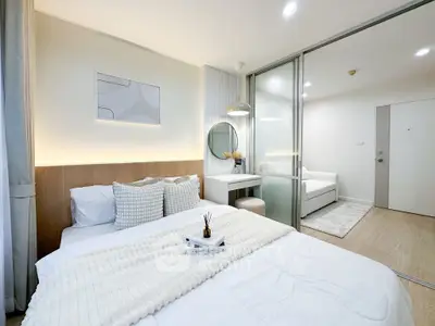 Modern bedroom with stylish decor and sliding glass partition in a cozy apartment.