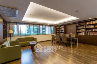 Spacious modern living room with wooden flooring and built-in bookshelves.