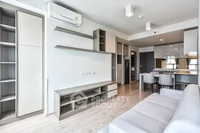Modern living room with sleek furniture and open kitchen layout in a stylish apartment.