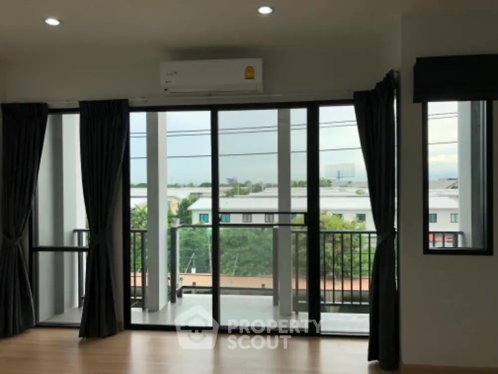 Spacious modern living room with large windows and balcony view