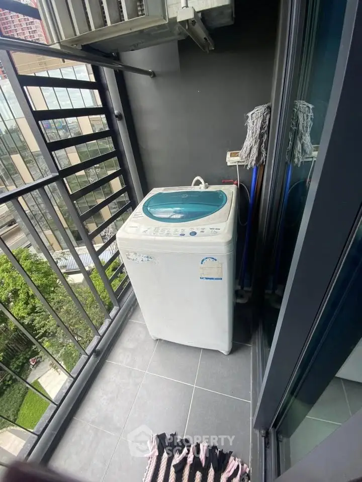 Compact balcony with washing machine and city view, ideal for urban living convenience.