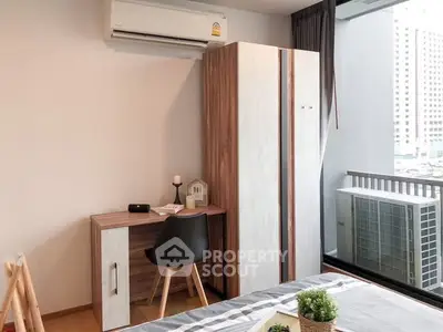 Modern bedroom with desk, wardrobe, and city view window.