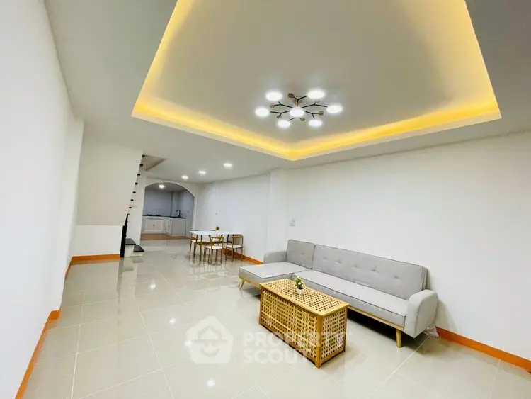 Spacious modern living room with stylish lighting and sleek furniture.