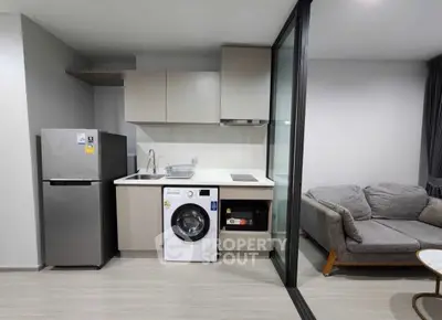 Modern apartment kitchen with washing machine and cozy living area