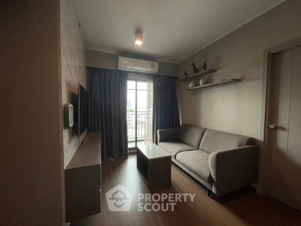 Cozy living room with modern sofa and wall-mounted TV, featuring a large window with city view.