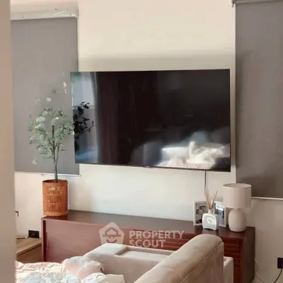 Modern living room with sleek TV, stylish decor, and cozy seating area.