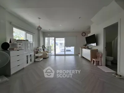 Spacious living room with modern decor and large windows leading to a balcony.