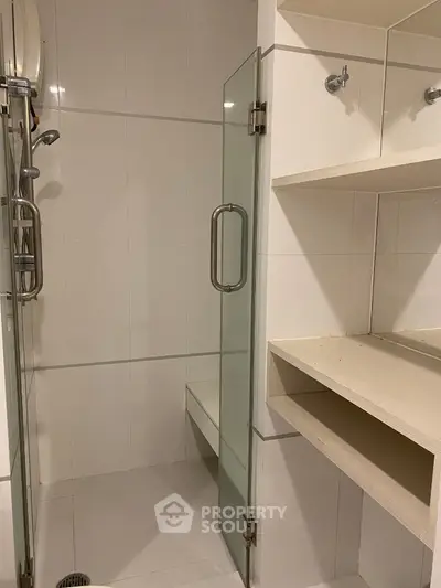 Modern bathroom with glass shower door and built-in shelving