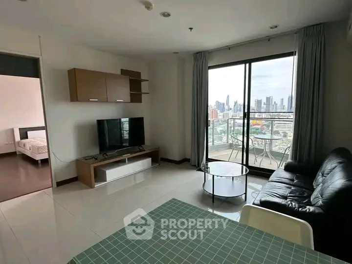 Modern living room with city view and balcony access in high-rise apartment.