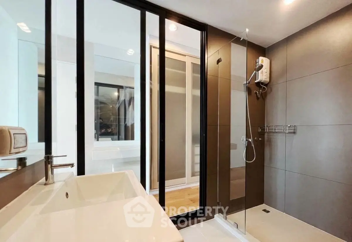Modern bathroom with sleek shower and stylish fixtures in contemporary apartment.