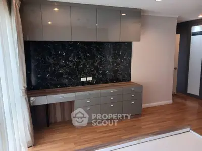 Modern interior with sleek cabinetry and marble backsplash in stylish apartment.