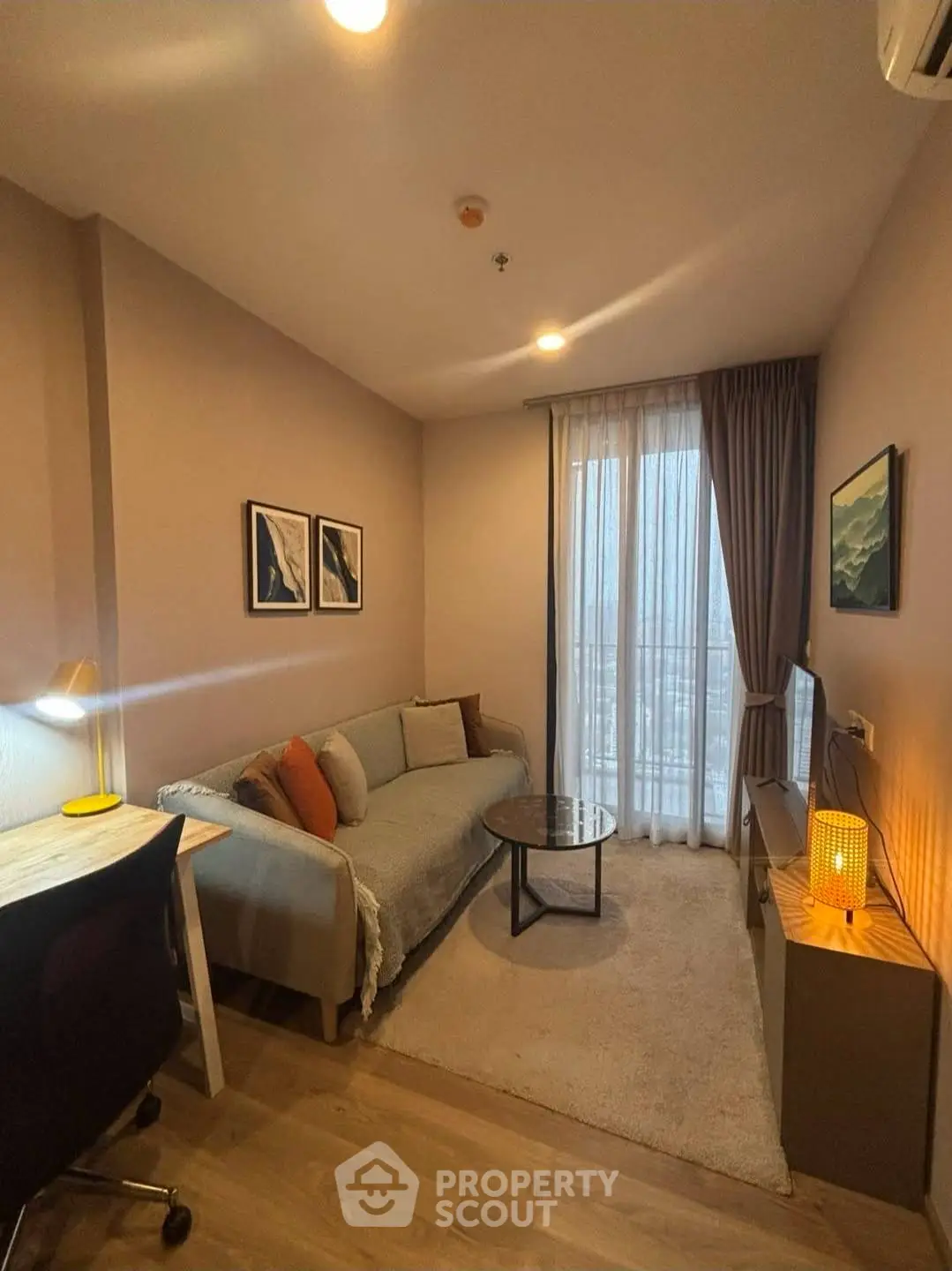 Cozy living room with modern decor, featuring a comfortable sofa, stylish artwork, and a warm ambiance.