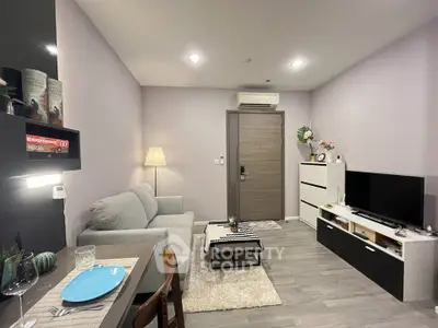 Modern living room with cozy sofa, stylish decor, and sleek TV setup in a contemporary apartment.