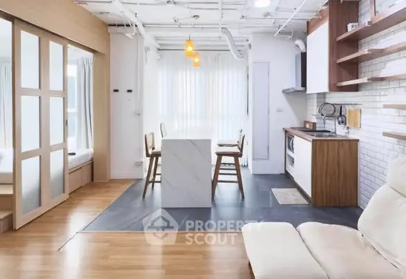 Modern open-layout kitchen and living area with sleek design and natural light.
