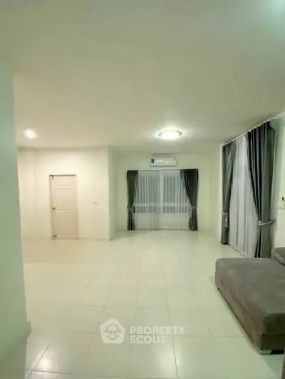 Spacious living room with modern decor and large windows for natural light.
