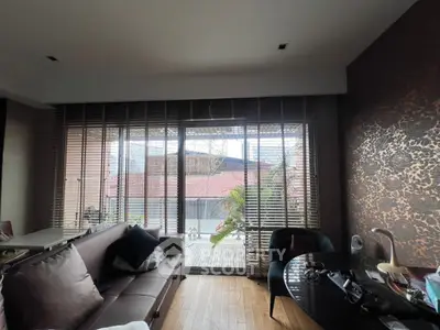 Stylish living room with large windows and elegant decor overlooking a serene outdoor view.
