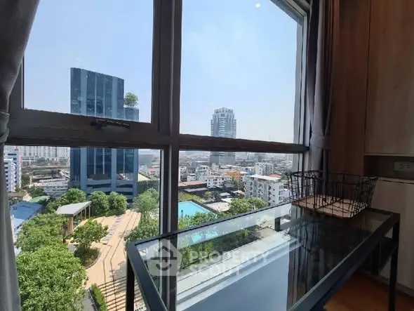 Stunning city view from modern high-rise apartment with glass table and basket.