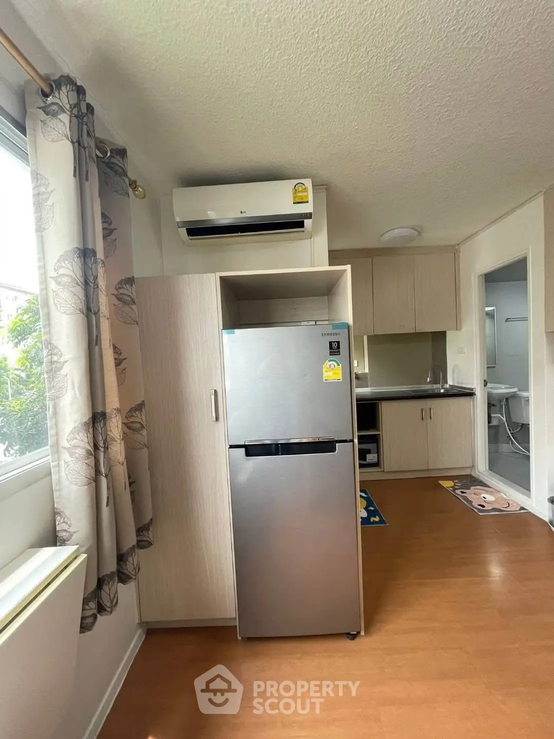 Modern kitchen with fridge and air conditioning in cozy apartment