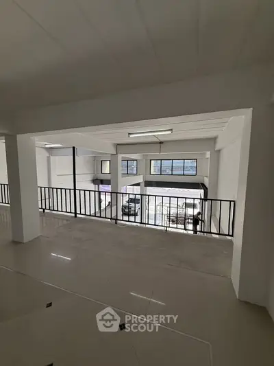 Spacious industrial-style interior with high ceilings and large windows for natural light.