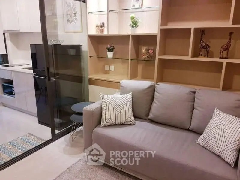 Modern living room with stylish sofa and open kitchen layout, perfect for cozy urban living.