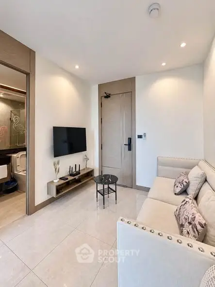 Modern living room with sleek design and wall-mounted TV, perfect for urban living.