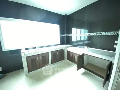 Spacious kitchen with modern cabinetry and ample natural light