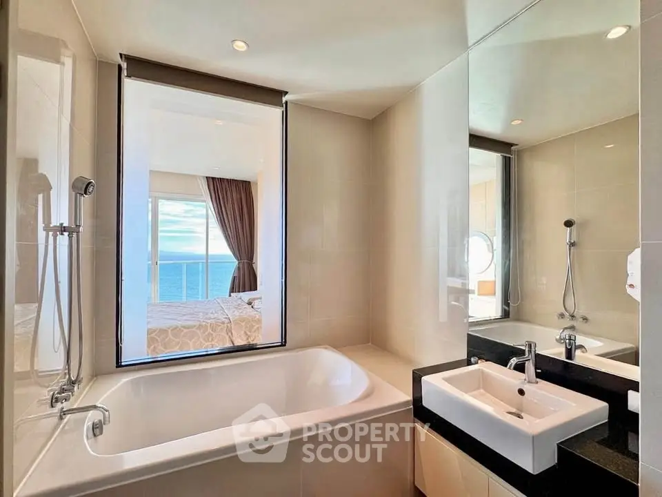 Luxurious bathroom with ocean view, featuring a sleek bathtub and modern fixtures.