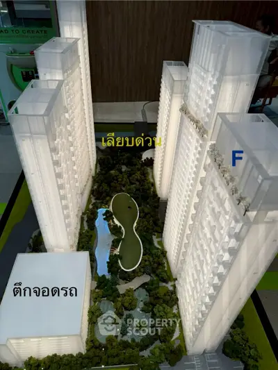 Architectural model of modern high-rise residential complex with lush green landscaping.