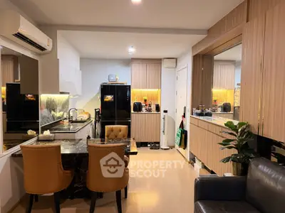Modern kitchen with open layout and stylish dining area featuring elegant chairs and sleek cabinetry.
