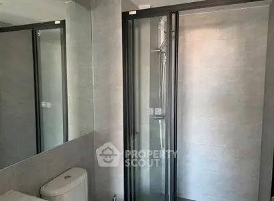Modern bathroom with sleek shower and toilet in contemporary design.