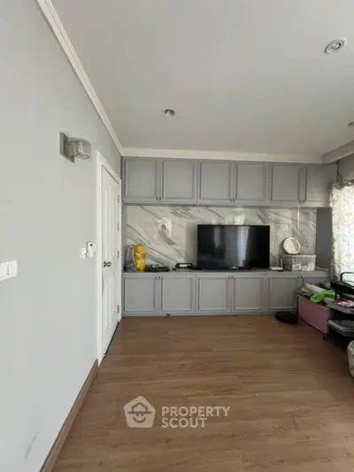 Modern living room with built-in TV cabinet and wooden flooring