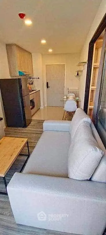 Modern apartment interior with cozy living area and compact kitchen, featuring stylish furniture and sleek design.