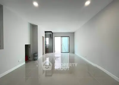 Spacious modern living room with glossy tiled floors and large windows for natural light.
