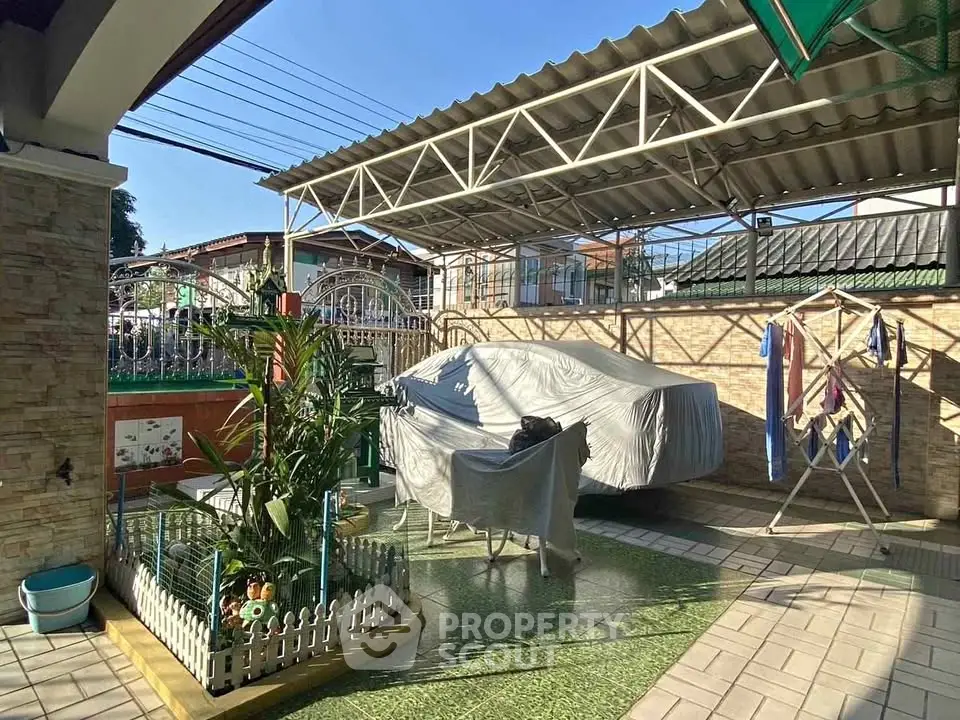 Charming covered outdoor area with garden and laundry space in residential property.