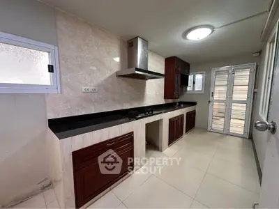 Spacious kitchen with modern cabinetry and gas stove, perfect for culinary enthusiasts.