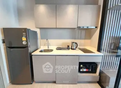 Modern compact kitchen with sleek appliances and minimalist design in a stylish apartment.