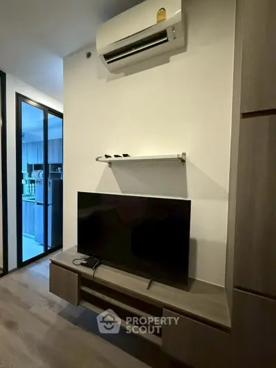 Modern living room with sleek TV setup and air conditioning unit