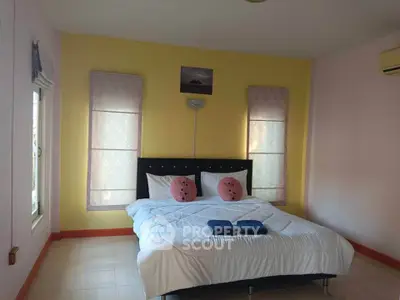 Cozy bedroom with bright yellow accent wall and modern decor