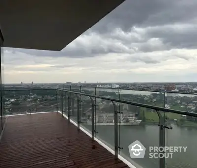 Stunning high-rise balcony with panoramic river view and modern glass railing.