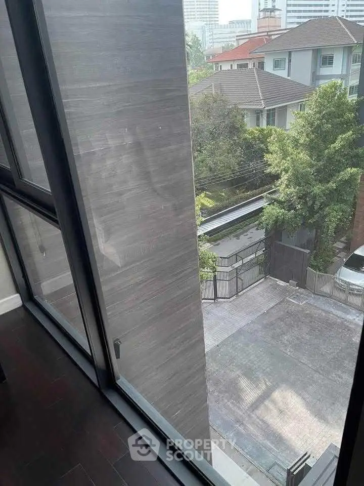 Modern urban view from high-rise apartment window overlooking residential area.