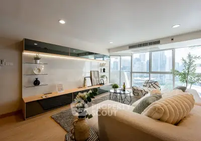 Spacious modern living room with city view, elegant decor, and natural light.