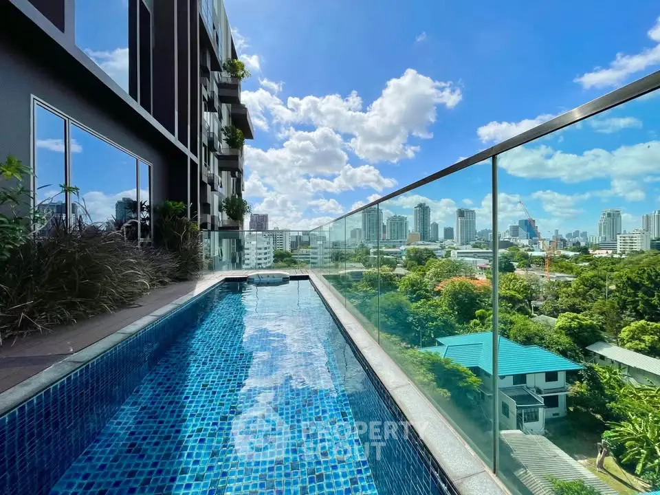 Luxurious rooftop pool with stunning city skyline view and glass railing.