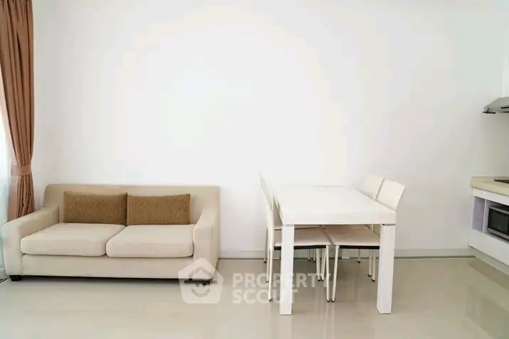 Modern minimalist living room with sleek white furniture and cozy beige sofa.